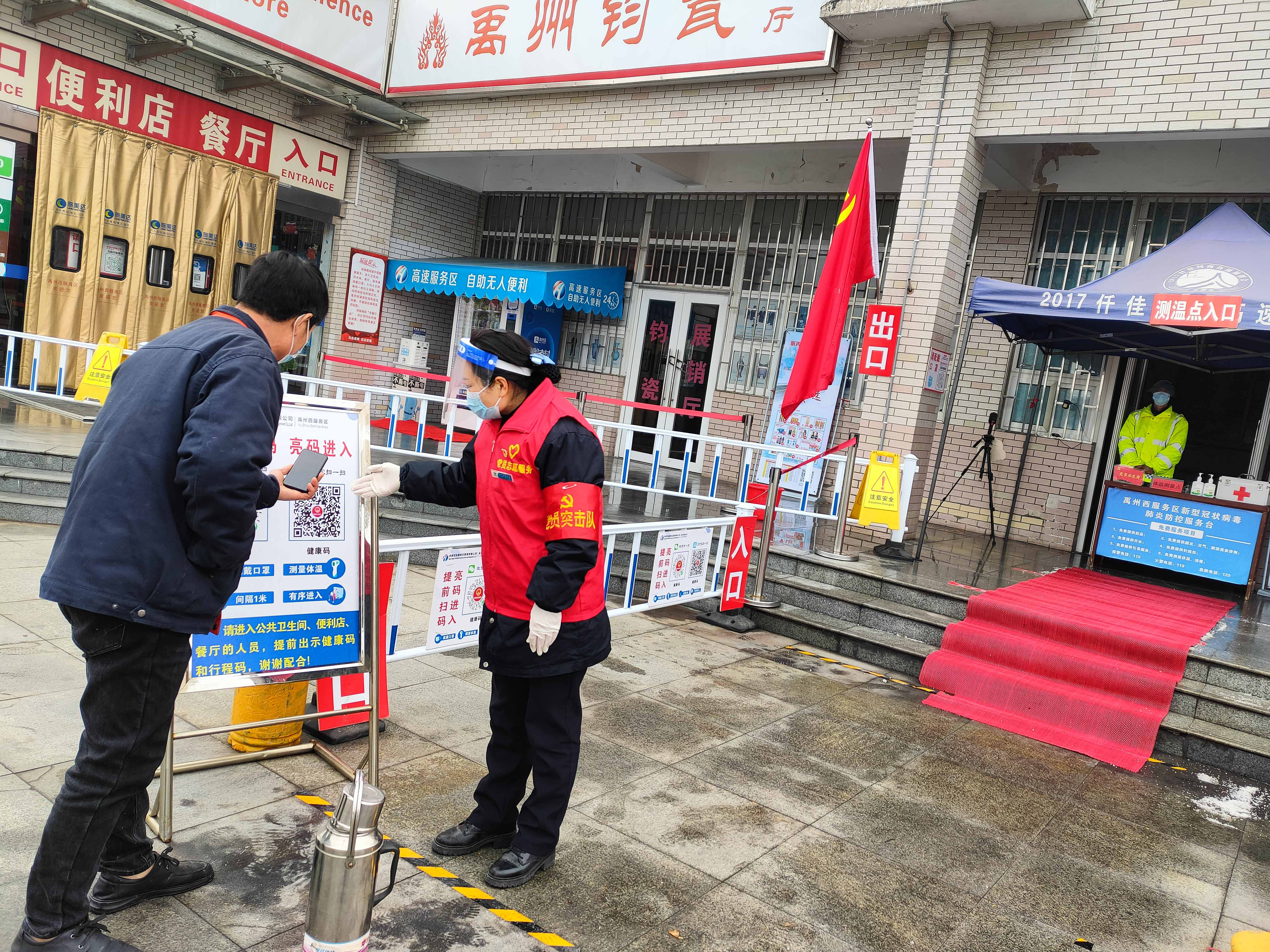 1月25日，禹州西服務(wù)區(qū)黨員志愿者嚴(yán)格執(zhí)行疫情防控工作，引導(dǎo)司乘朋友速快掃碼，代查健康碼服務(wù)。李會(huì)軍  攝.jpg
